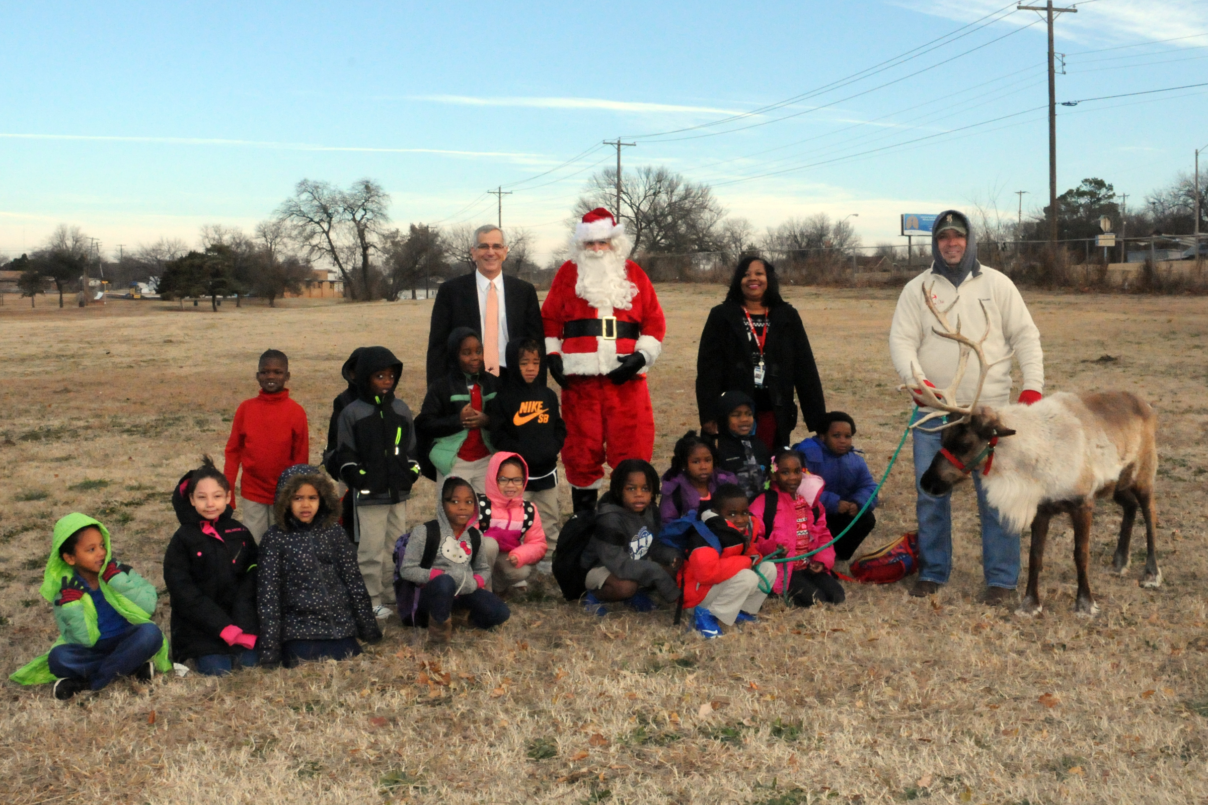 Secretary of Agriculture Jim Reese poses with Santa and students from F. D. Moon Academy in Oklahoma City during a visit with Prancer the reindeer.